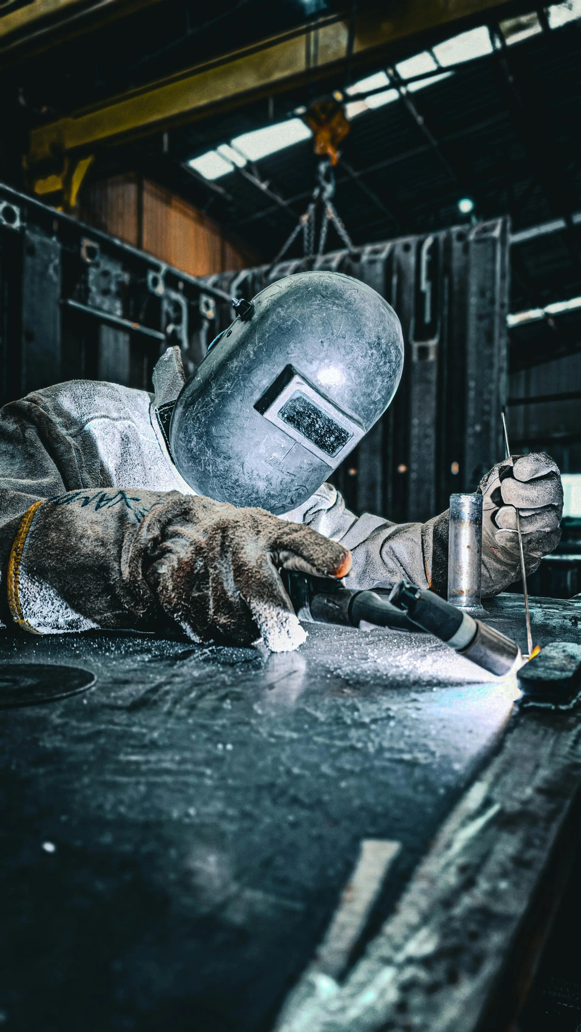 Welder in full protective gear at work